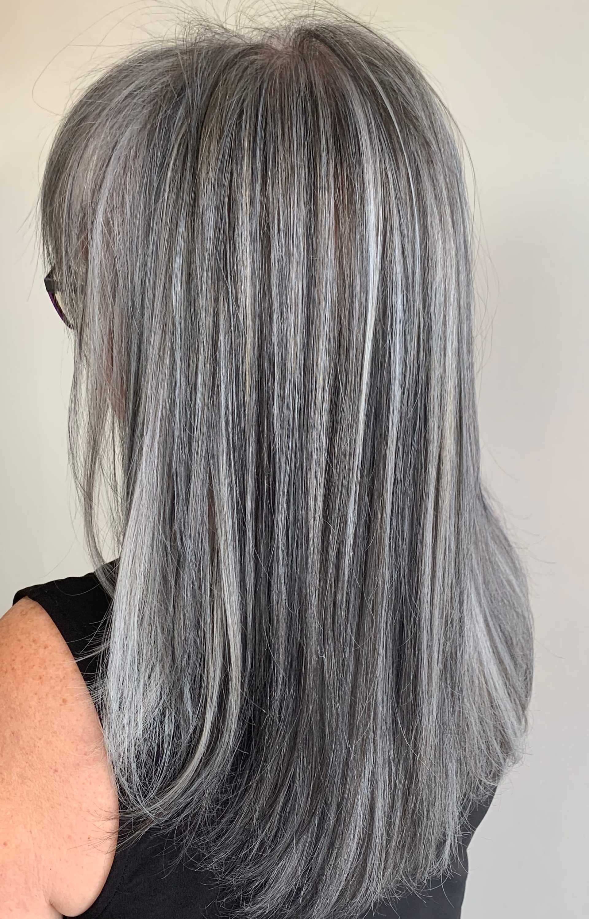 Straight gray hair with natural highlights flowing down a person's back.